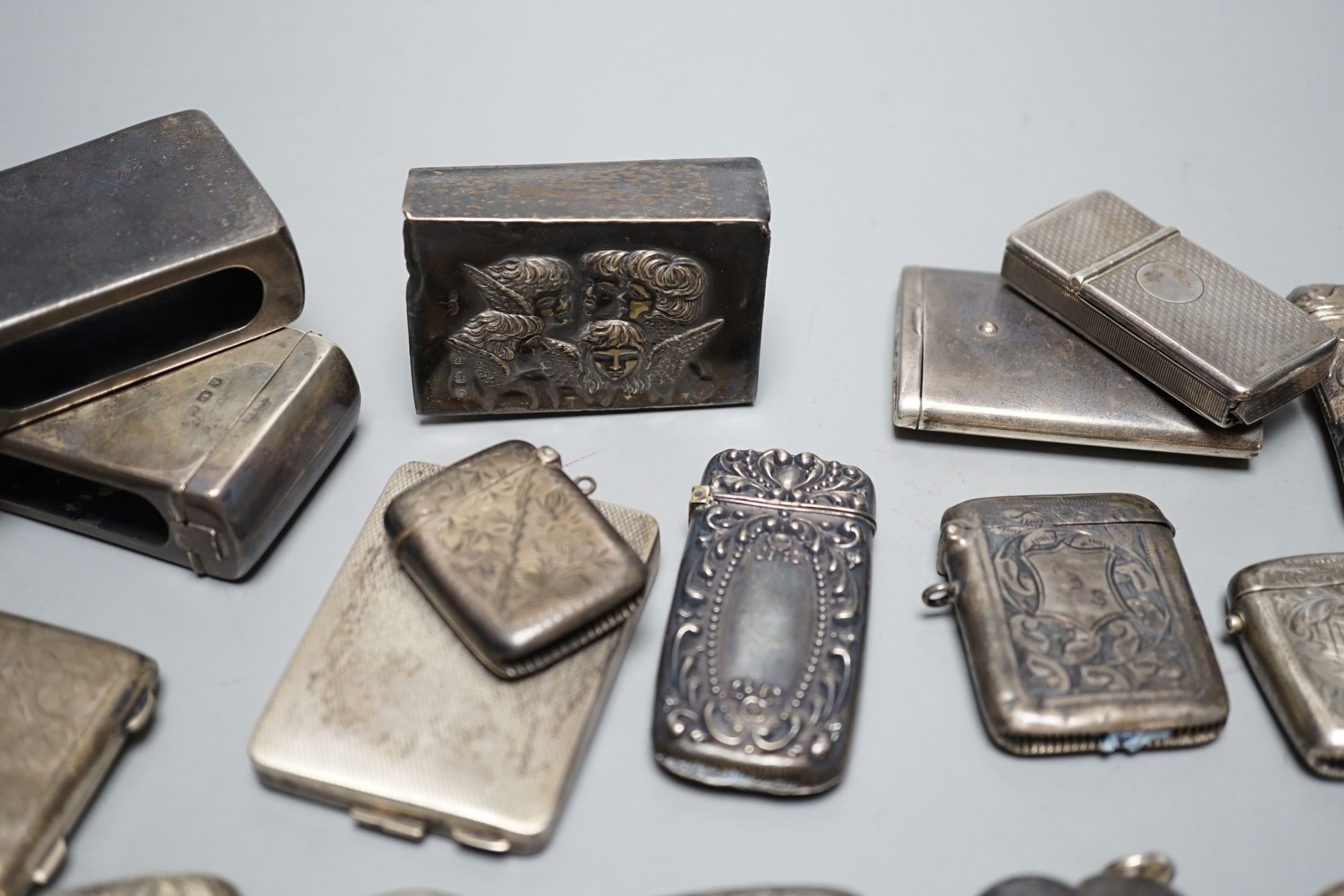 A collection of twenty six assorted mainly early 20th century silver or white metal vesta cases, including heart shape and combination vesta and cheroot cutter, largest 61mm and and seven assorted match cases or sleeves.